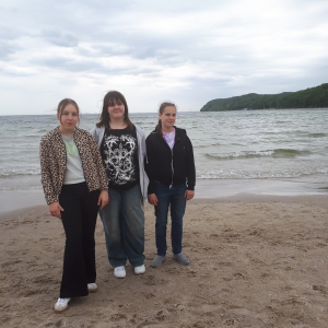 Trzy uczennice na plaży, w tle morze. Kliknięcie w zdjęcie spowoduje powiększenie do oryginalnego rozmiaru.