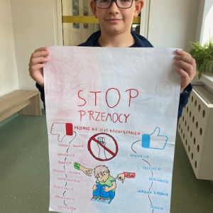 Uczeń trzyma plakat. Kliknięcie w zdjęcie spowoduje powiększenie do oryginalnego rozmiaru.