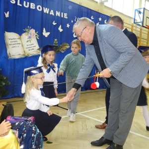 Pan dyrektor pasuje uczennicę klasy pierwszej. Kliknięcie w zdjęcie spowoduje powiększenie do oryginalnego rozmiaru.