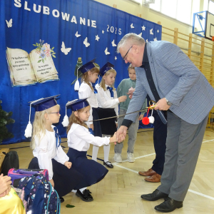 Pan dyrektor pasuje uczennicę klasy pierwszej. Kliknięcie w zdjęcie spowoduje powiększenie do oryginalnego rozmiaru.