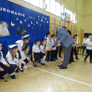 Pan dyrektor pasuje uczennicę klasy pierwszej. Kliknięcie w zdjęcie spowoduje powiększenie do oryginalnego rozmiaru.