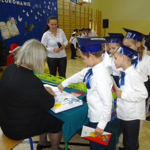 Uczeń klasy pierwszej odbija palec w księdze pamiątkowej. Kliknięcie w zdjęcie spowoduje powiększenie do oryginalnego rozmiaru.