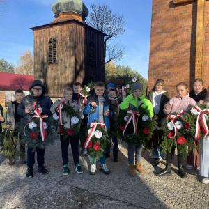 Grupa uczniów klasy 5 z wiązankami na placu przed Kościołem Parafialnym. Kliknięcie w zdjęcie spowoduje powiększenie do oryginalnego rozmiaru.
