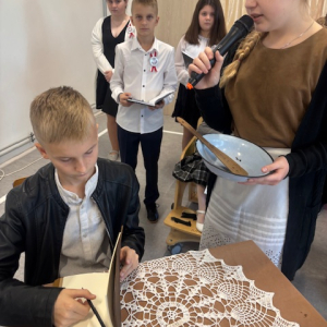 Uczennica i uczeń w czasie występu. Kliknięcie w zdjęcie spowoduje powiększenie do oryginalnego rozmiaru.