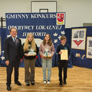 Troje uczniów z dyplomem i nagrodami, obok stoi poseł. Kliknięcie w zdjęcie spowoduje powiększenie do oryginalnego rozmiaru.