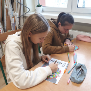 Dwie uczennice kolorują obrazki. Kliknięcie w zdjęcie spowoduje powiększenie do oryginalnego rozmiaru.