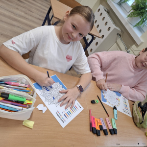 Dwie uczennice kolorują obrazki. Kliknięcie w zdjęcie spowoduje powiększenie do oryginalnego rozmiaru.