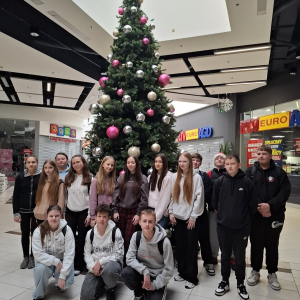 Grupa uczniów klasy ósmej przed choinką. Kliknięcie w zdjęcie spowoduje powiększenie do oryginalnego rozmiaru.