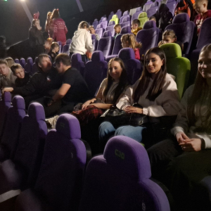 Kilkoro uczniów w sali kinowej. Kliknięcie w zdjęcie spowoduje powiększenie do oryginalnego rozmiaru.