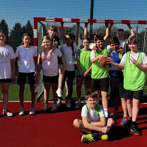 Międzyklasowy turniej sportowy z okazji pierwszego dnia wiosny. Uczniowie kl. 7  przed grą na boisku szkolnym. Kliknięcie w zdjęcie spowoduje powiększenie do oryginalnego rozmiaru.