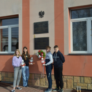 Uczniowie przed pamiątkową tablicą. Kliknięcie na zdjęcie spowoduje jego powiększenie do oryginalnego rozmiaru.